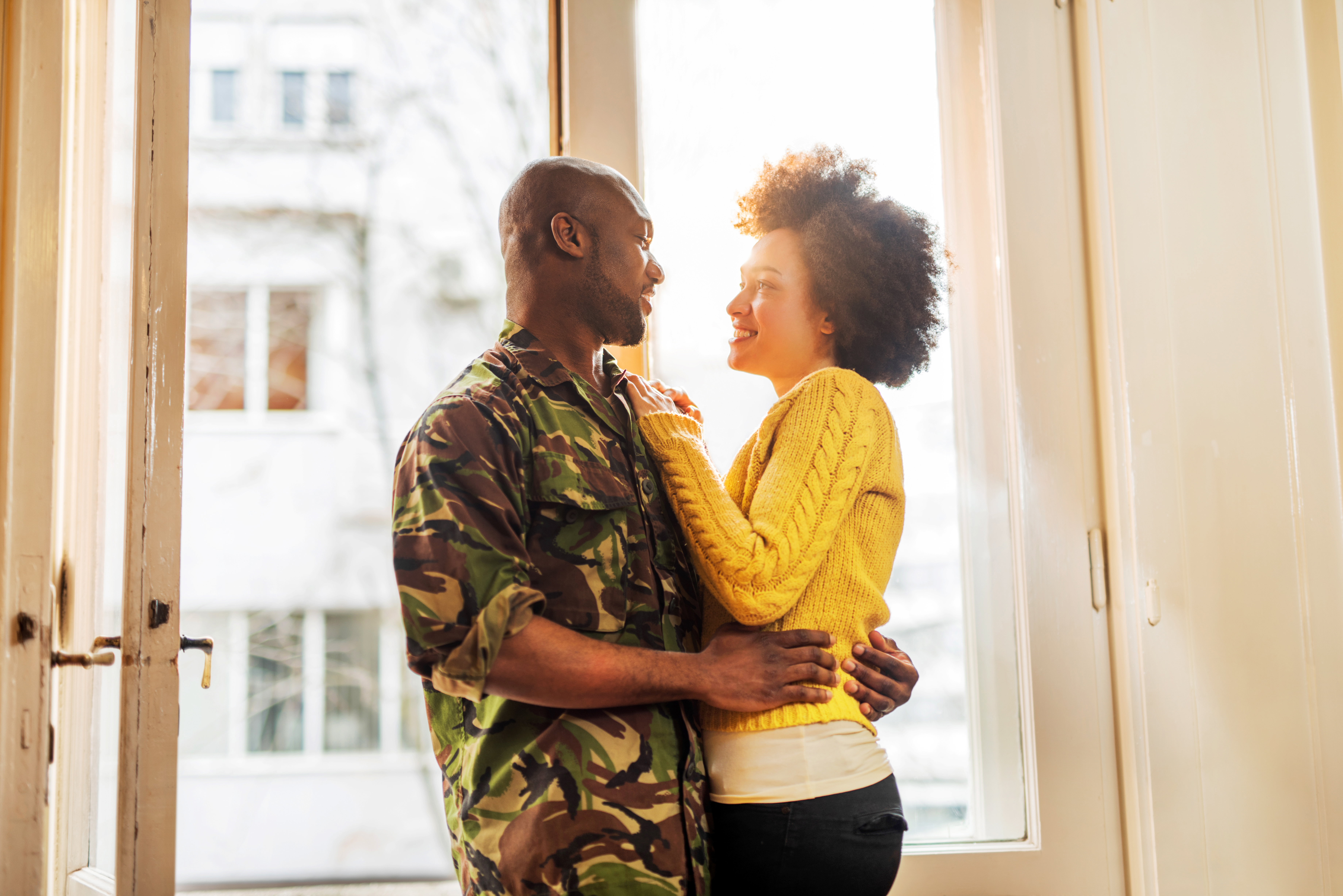 Happy African American soldier coming home to his wife.